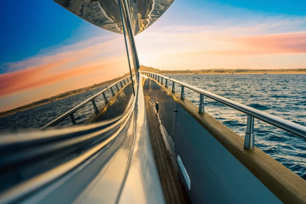 Teak side deck and rails of a motor yacht at sunset