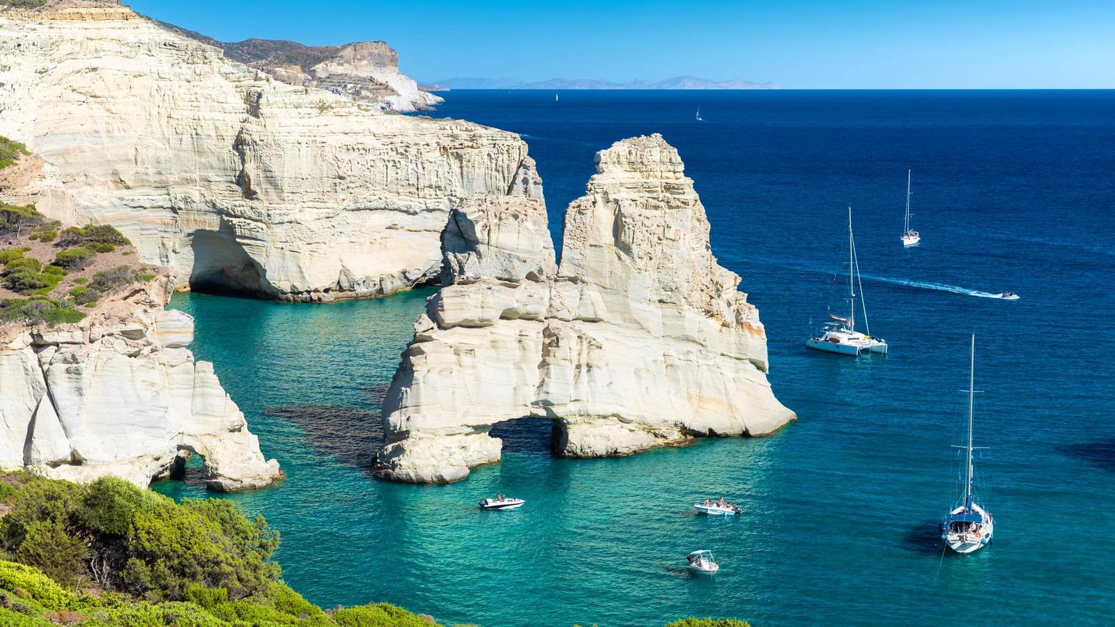 Sailing yachts anchored by the white rock formations of Kleftiko, Milos