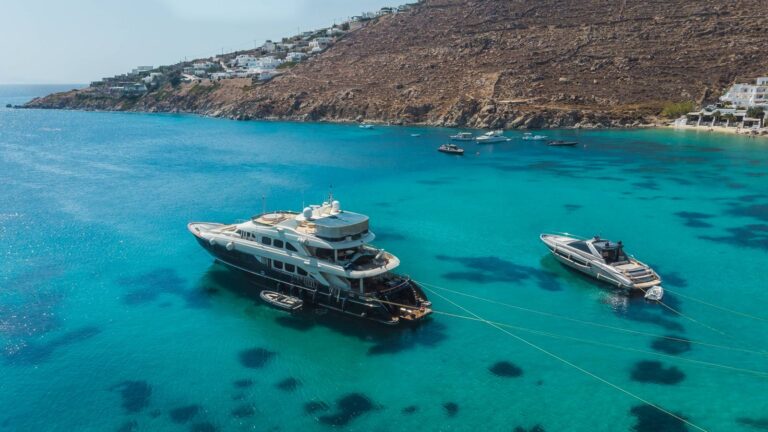 Superyacht and motor yacht anchored in the turquoise water of Psarou Bay, Mykonos